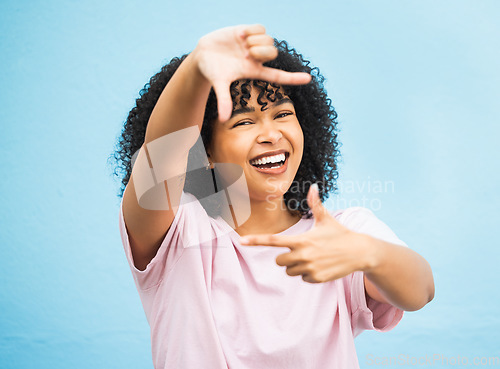 Image of Black woman, hands and smile for frame, picture perfect or photo against a blue studio background. Portrait of African American female, person or lady model smiling showing finger sign in photography