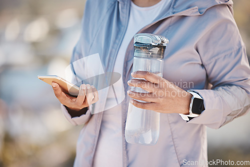 Image of Running, water and phone with hands of woman in mountain for jogging, workout or cardio training. Social media, progress tracker or fitness app with runner on path checking mobile for endurance goals