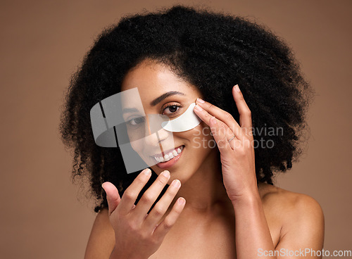 Image of Face, skincare and black woman with eye patch in studio on a brown background. Portrait, makeup and cosmetics of female model with facial collagen pad or product for anti aging, hydration or wellness