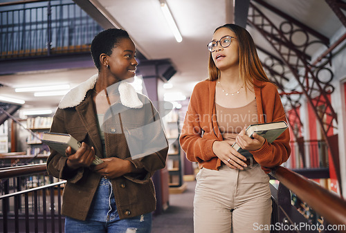 Image of College students, library books and women talking about education and learning together at university. Friends having conversation about knowledge, studying and research on scholarship while walking