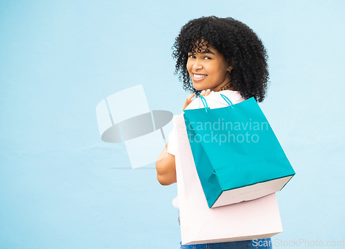 Image of Back, portrait and black woman with bags, shopping and purchase expensive items with girl on blue studio background. Mockup, Jamaican female and customer with boutique clothes, retail and discount