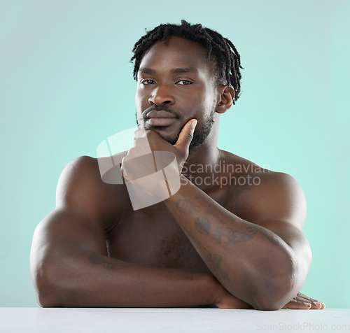 Image of Confident, handsome and portrait of a young black man isolated on a blue background in studio. Sexy, skincare and healthy body of an African model with muscle, confidence and seduction on a backdrop