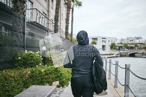 Image of Fitness, hoodie or man walking to gym for body training, exercise or workout with a duffle bag in Miami, Florida. City, mindset or healthy sports athlete with wellness goals, motivation or mission