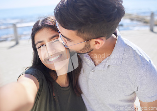 Image of Couple, love and selfie at the beach, travel and kiss by ocean with support, trust and care with adventure in Mumbai. Smile in picture, happy and memory with smartphone photography for romance