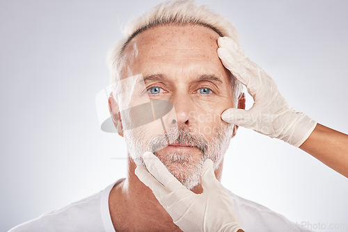 Image of Man face, hands or cosmetic surgery gloves on studio background for skincare collagen, medical dermatology or anti aging grooming. Portrait, plastic surgeon or mature patient check for facial change