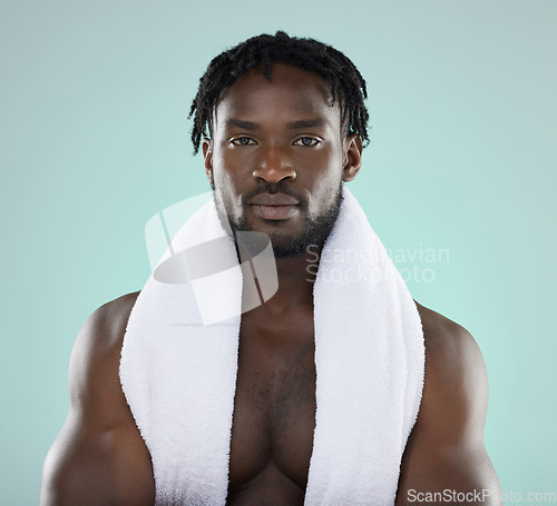 Image of Black man, skincare and portrait of face with towel for beauty, hygiene and grooming in studio. Healthy person on blue background for facial glow, clean skin and self care with dermatology cosmetic