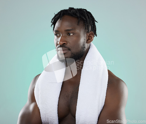 Image of Wellness, grooming and black man thinking of a shower, cleaning and isolated on a blue background. Beauty, health and African model with a towel for cosmetic morning routine on a studio backdrop