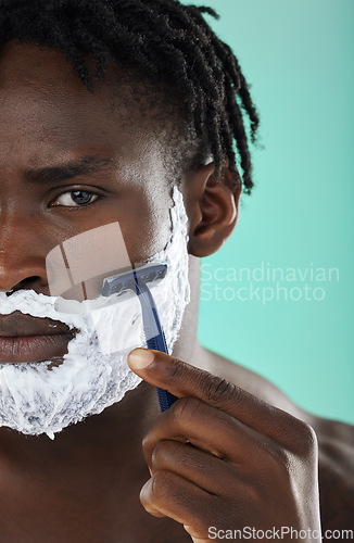 Image of Black man, shaving and studio with skincare foam, razor and facial cosmetics for beauty by blue background. African gen z model, hair removal cream and shave for aesthetic, cleaning and face grooming