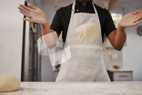 Image of Baking, dough and hands of a cook in the kitchen for cooking food, bread or a pastry in a bakery. Fast food, job and man preparing a breakfast, lunch or dinner on a table of a shop for a meal