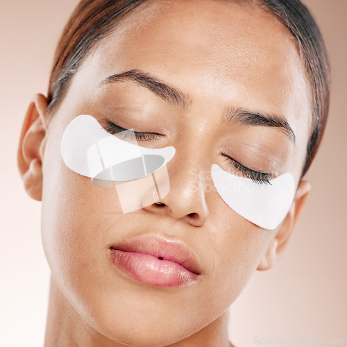 Image of Eyes patch, skincare and woman in studio for facial cosmetics, face dermatology and self care glow, shine or health. Young beauty model with collagen mask product and application for circle under eye