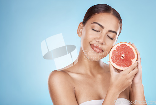 Image of Skincare, grapefruit and happy wellness woman satisfied with vitamin c body care glow treatment. Aesthetic, detox and natural cosmetic model in blue studio with beauty marketing mockup.