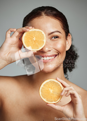 Image of Woman, smile and orange in studio for skincare, health and wellness with cosmetic glow, self care and backdrop. Model, black woman and fruit for cosmetics, detox or healthy natural skin by background