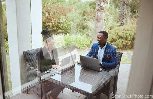 Image of Business people, man and black woman in meeting on terrace, laptop and finance goal on business trip. Black man, woman and teamwork in morning business meeting on patio, hotel or garden for planning