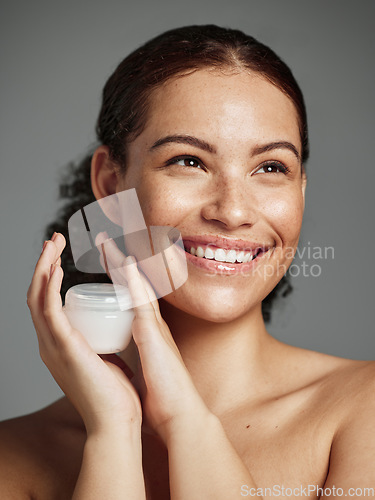 Image of Wellness, aesthetic and facial cream of black woman with healthy beauty glow and natural freckles. Thinking skincare girl with smile and luxury face lotion product on gray studio background.