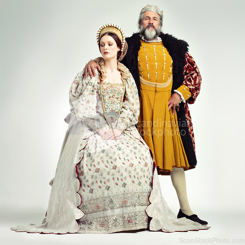 Image of King, queen and crown with a couple in studio on a gray background during the renaissance or victorian period. Royalty, history and vintage with a man and woman monarch, leader or ruler of a kingdom