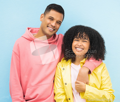 Image of Happy couple, smile portrait and cool fashion standing in blue background for love, support and care. Black woman, man and happiness hug together for trendy gen z or millenial street style clothes