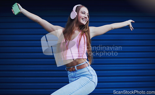 Image of Woman, headphones and dancing outdoor for celebration, achievement and streaming music for fun. Young female, lady or headset for radio, listen to audio or songs with confident girl and casual outfit
