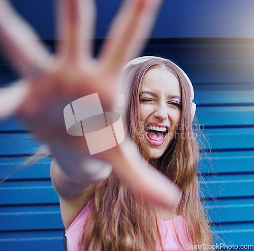 Image of Music, dance and wink with a woman reaching on a blue background while listening to the radio. Freedom, fun and audio with an attractive young female streaming a playlist or song while dancing