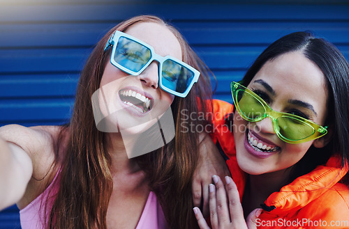 Image of Selfie, gen z and portrait of fun women in the city with fashion, sunglasses and happy in Korea. Smile, stylish and face of friends with a photo, streaming and crazy on a blue wall with style