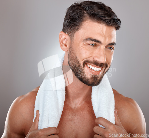 Image of Man with towel, beauty and face with skincare, hygiene and self care against studio background. Grooming, skin and glow with cosmetic, facial wellness and happy male with beard, clean teeth and smile