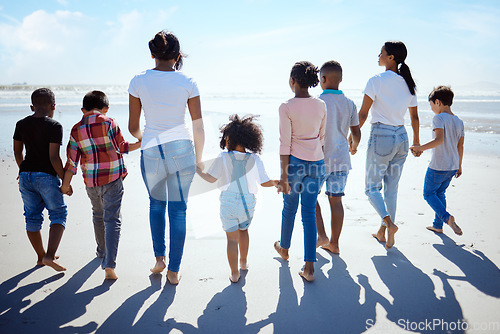 Image of Big family, beach walk and summer for holiday, sunshine and bonding with interracial diversity by water. Happy family, lesbian mom and holding hands for solidarity, care and love on vacation by sea