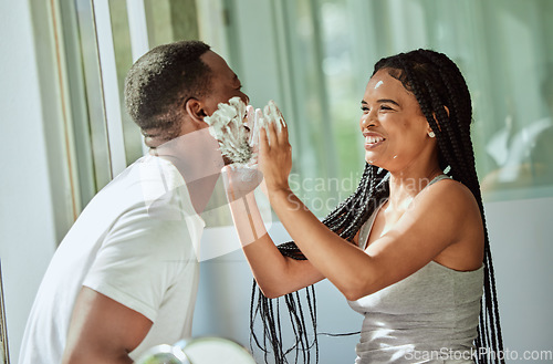 Image of Shave, playing and funny with a black couple laughing or joking together in the bathroom of their home. Love, shaving and laughter with a man and woman having fun while bonding in the morning