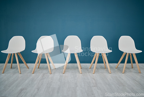 Image of Chairs, line and waiting room in the office corridor for an interview, meeting or recruitment. Seats, row and empty stools in the hallway or boardroom of the modern business workplace for hiring.