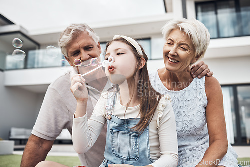 Image of Smile, family and girl with bubbles and grandparents enjoying weekend, holiday and quality time together. Love, home and happy girl, grandmother and grandfather bonding, relaxing and fun in garden