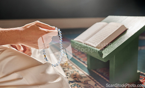 Image of Quran, beads or hands praying in Islamic or Muslim religion to Allah for spiritual peace or freedom in mosque in Qatar. Muslim pray, reading or person kneeling on carpet in holy temple to praise God