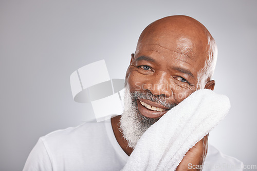 Image of Skincare, portrait or old man with a face towel in studio with marketing or mock up space for beauty. Happy smile, glowing skin or healthy senior black man grooming with facial cosmetics or product