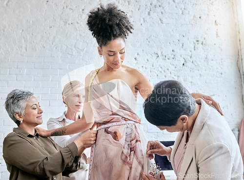 Image of Designer women, model and fitting dress for focus, design or teamwork for runway fashion in workshop. Happy team, woman collaboration and success vision for diversity, goals or helping hand in studio