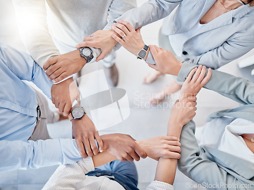 Image of Above business people, trust circle and holding hands for motivation, teamwork or group goal at finance company. Businessman, women and helping hand for support, diversity and solidarity in workplace