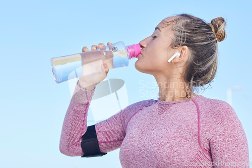 Image of Woman runner, water bottle and music with earphones for focus, workout and outdoor training for health. Girl, wellness and hydration for running, exercise or streaming audio in summer for strong body