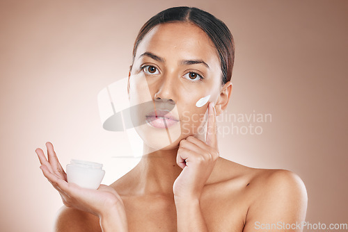 Image of Skincare, beauty and woman with cream glow, face cosmetics and advertising spa product on a studio background. Collagen, dermatology and portrait of a model marketing sunscreen for facial health