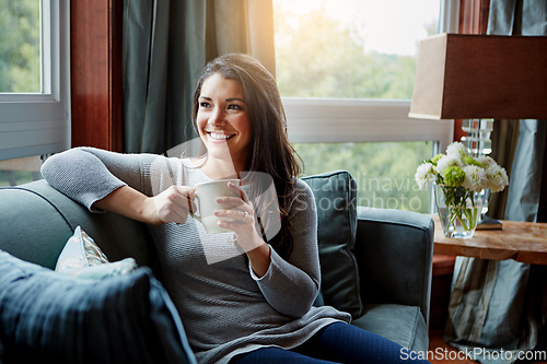 Image of Happy woman, coffee or tea and home sofa while thinking of idea, future and memory to relax. Female with a smile on living room couch drinking from a cup for positive mindset, happiness and wellness