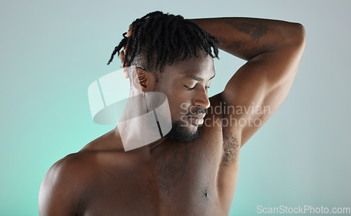 Image of Armpit, wellness and black man with skincare hygiene or grooming isolated against a studio background. Natural, cosmetics and body care for healthy skin by a young, confident and African model