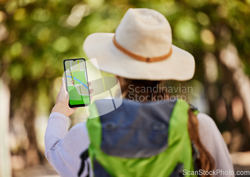 Image of GPS, direction and woman hiking in a forest for exercise, adventure or wellness in nature. Navigation app, phone and female hiker trekking on an outdoor trail in the woods alone with a mobile map.