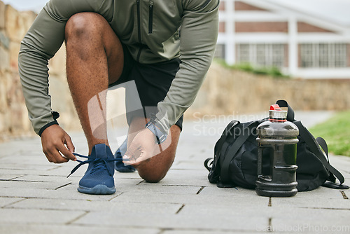 Image of Fitness, sports shoes and black man tie before outdoor cardio exercise or workout in the park. Sport, runner and African male athlete preparing for endurance training for race, challenge or marathon.