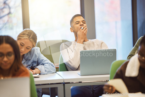 Image of Education, man and student tired, classroom and studying for exams, laptop and learning. Male, academic and exhausted for test, overworked and fatigue with research work, college stress and burnout