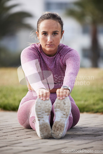 Image of Woman, exercise and fitness portrait while stretching outdoor at a city park for health and wellness. Athlete female sitting for warm up, cardio workout and running for healthy lifestyle and body