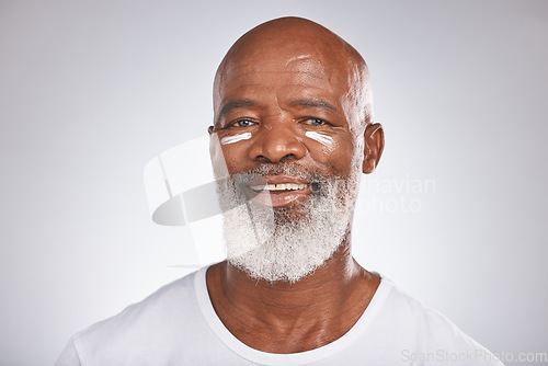 Image of Facial cream, beauty and skincare of senior man in studio for self care with dermatology and cosmetics product on skin. Portrait of happy black male with sunscreen or lotion for glow and moisturizer