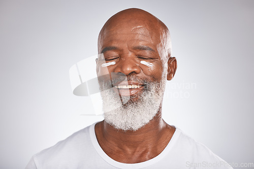 Image of Beauty, facial cream and skincare of black man in studio for dermatology, cosmetics and self care on grey. Face of happy senior male with sunscreen or lotion on skin for glow, health and wellness