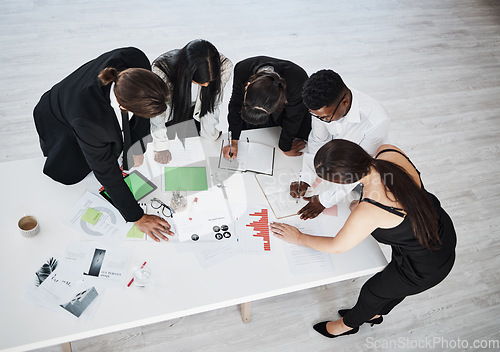 Image of Meeting, accounting and collaboration with a business team working around a table in the boardroom from above. Finance, documents and teamwork with a man and woman employee group at work in an office