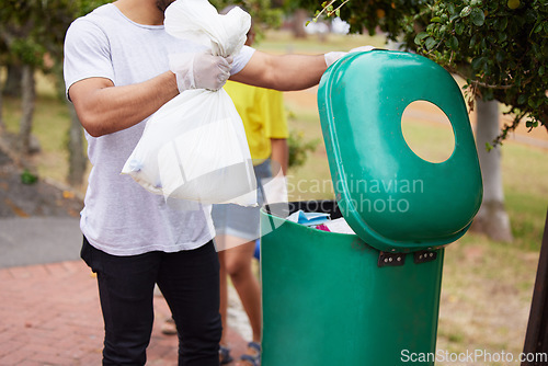 Image of Volunteer cleaning, trash bin and man throw garbage, pollution or waste product for environment support. Community help, NGO charity and eco friendly people helping with nature park plastic clean up