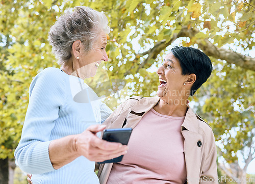 Image of Senior women, laughing or phone meme in nature park, garden or relax environment in retirement, support or trust. Smile, happy friends or elderly bonding with comic, crazy or funny joke on technology