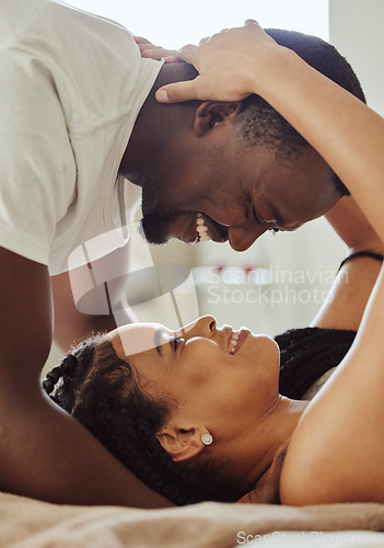 Image of Black couple, love and home bedroom romance while happy and intimate together on bed at home, apartment or hotel. Face of young man and woman in happy marriage with commitment and care on honeymoon