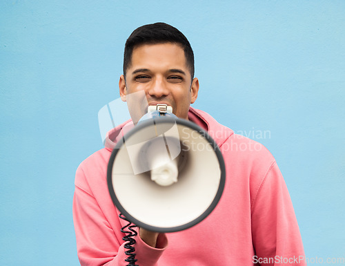 Image of Portrait, protest and megaphone with a man in studio on a blue background for an announcement or speech. Freedom, human rights and loudspeaker with a male at a rally for equality or revolution