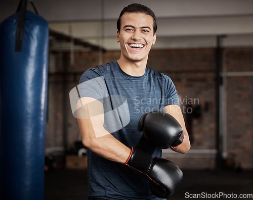 Image of Fitness, portrait and man with boxing gloves in gym for training, exercise or training. Happy, smile and male athlete or boxer doing cardio kickboxing workout for health or wellness in sports studio.