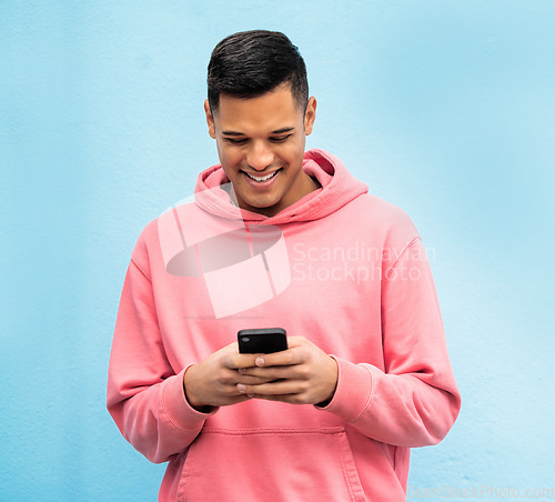 Image of Happy man, fashion or phone typing on isolated blue background in Brazil city on social media, app or internet. Smile, person or student model on mobile communication technology by urban wall mock up