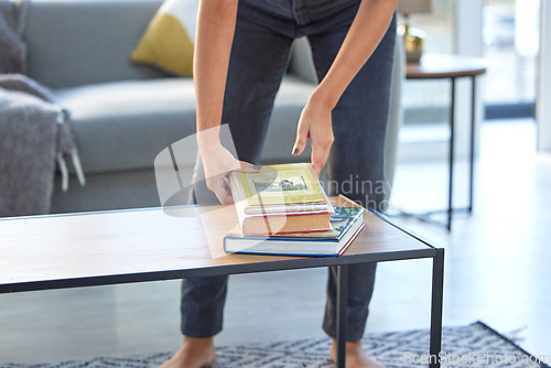 Image of Woman, hands and student pick up books on table for studying in living room home. Education, learning and female with imagine the possibilities novel, textbooks and story books for reading in house.